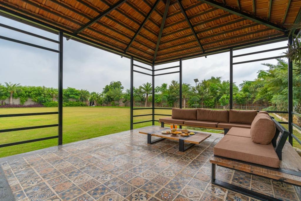 Evening gathering around bonfire at Auric Acres private pool villa near Delhi
