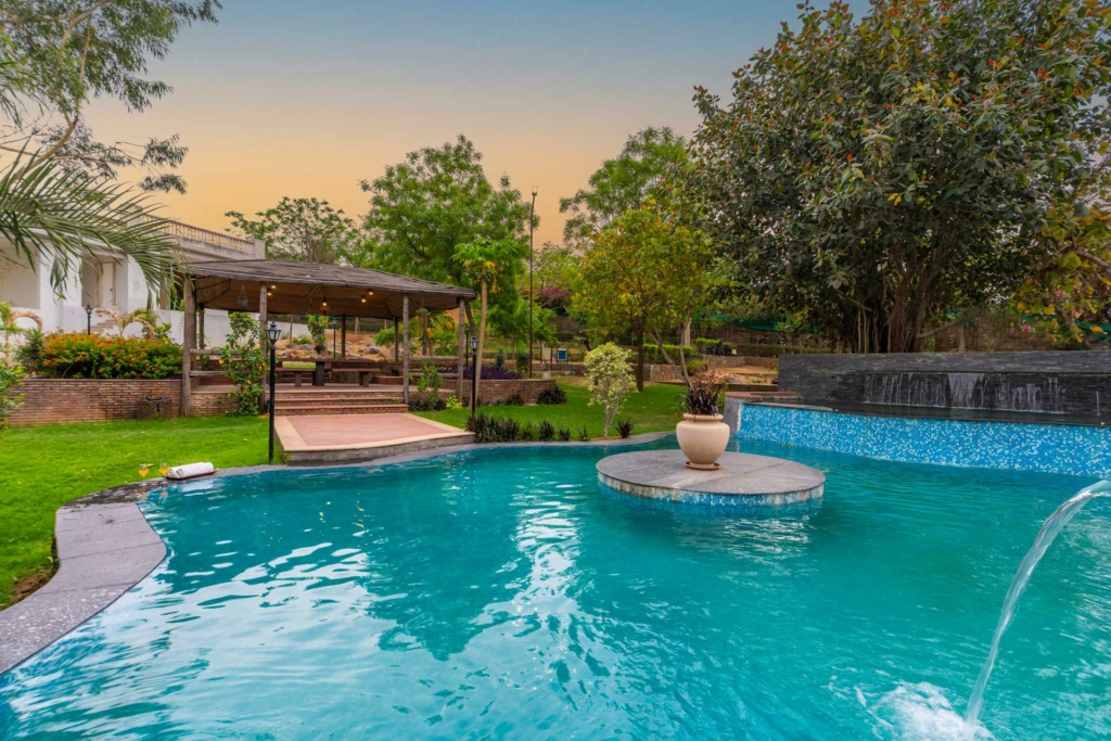 Relaxing seating area by the pool at Maple Farms villa near Delhi