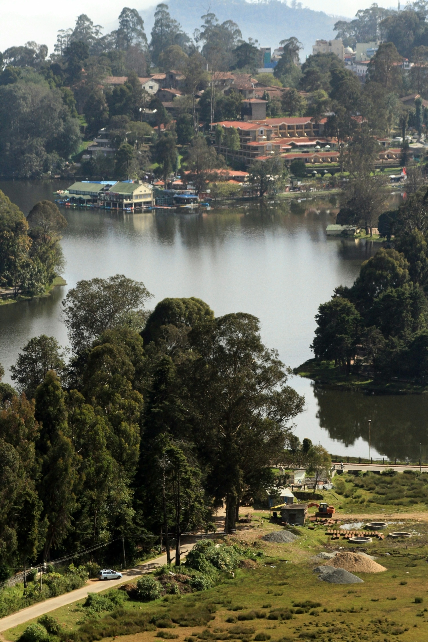 Calm waters of Kodaikanal Lake framed by green pines in May 2026